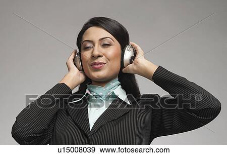 Stock Photo - Businesswoman enjoying music on headphones. Fotosearch