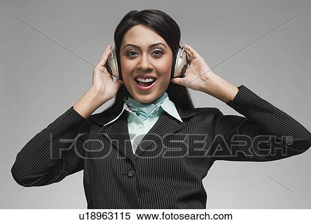 Stock Photography - Businesswoman enjoying music on headphones. Fotosearch