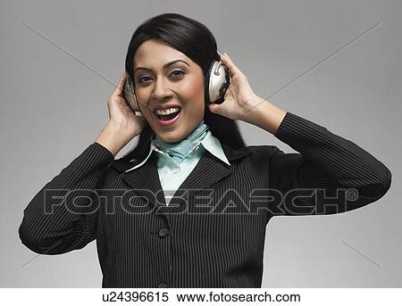Stock Photography - Businesswoman enjoying music on headphones. Fotosearch