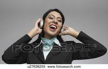 Businesswoman enjoying music on headphones View Large Photo Image Stock Photography - Businesswoman enjoying music on headphones. Fotosearch