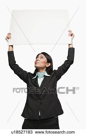 Stock Image - Businesswoman holding a placard over her head. Fotosearch