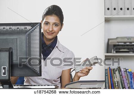 Stock Photo - Businesswoman holding a telephone receiver. Fotosearch
