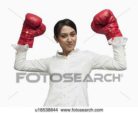 Businesswoman in boxing gloves cheering with arms raised View Large Photo Image Picture - Businesswoman in boxing gloves cheering with arms raised. Fotosearch