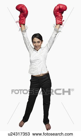 Businesswoman in boxing gloves cheering with arms raised View Large Photo Image Stock Image - Businesswoman in boxing gloves cheering with arms raised. Fotosearch