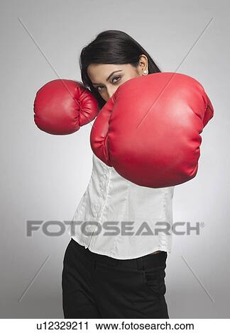 Businesswoman punching with boxing gloves View Large Photo Image Stock Image - Businesswoman punching with boxing gloves. Fotosearch