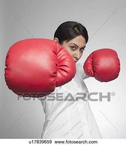 Businesswoman punching with boxing gloves View Large Photo Image Stock Photo - Businesswoman punching with boxing gloves. Fotosearch