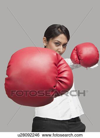 Businesswoman punching with boxing gloves View Large Photo Image Stock Photograph - Businesswoman punching with boxing gloves. Fotosearch