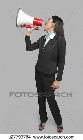 Businesswoman shouting into a megaphone View Large Photo Image Picture - Businesswoman shouting into a megaphone. Fotosearch
