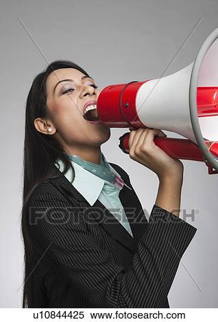 Businesswoman shouting into a megaphone View Large Photo Image Stock Photography - Businesswoman shouting into a megaphone. Fotosearch
