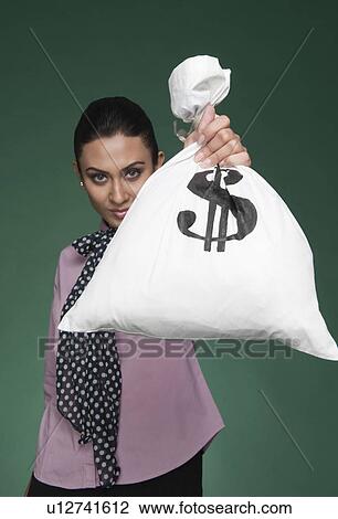 Stock Image - Businesswoman showing a money bag. Fotosearch