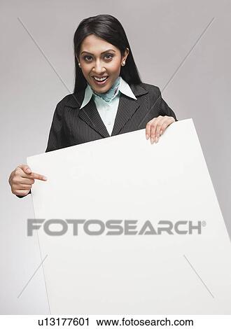 Stock Image - Businesswoman showing a placard and smiling. Fotosearch