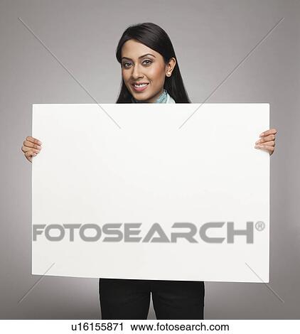 Stock Image - Businesswoman showing a placard and smiling. Fotosearch