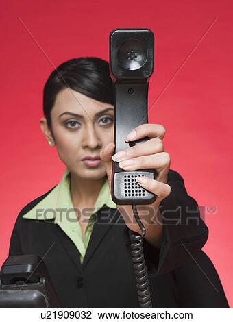 Businesswoman showing a telephone receiver View Large Photo Image Stock Image - Businesswoman showing a telephone receiver. Fotosearch