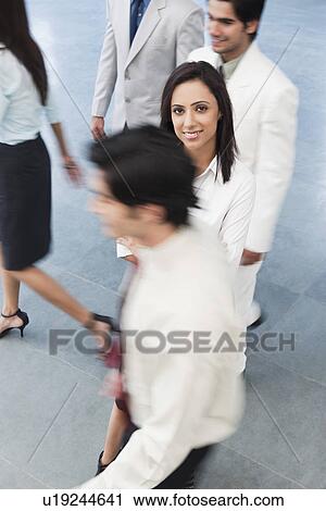 Businesswoman smiling with their colleagues around her View Large Photo Image Stock Image - Businesswoman smiling with their colleagues around her. Fotosearch