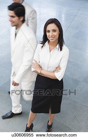 Stock Photography - Businesswoman standing with arms crossed and smiling. Fotosearch