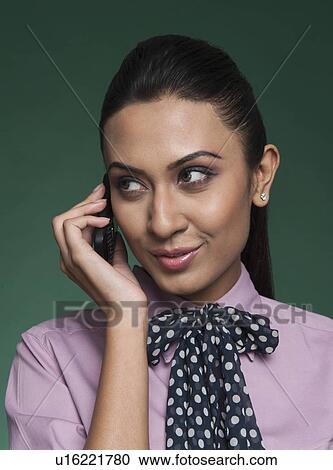 Businesswoman talking on a mobile phone and smiling View Large Photo Image Stock Image - Businesswoman talking on a mobile phone and smiling. Fotosearch