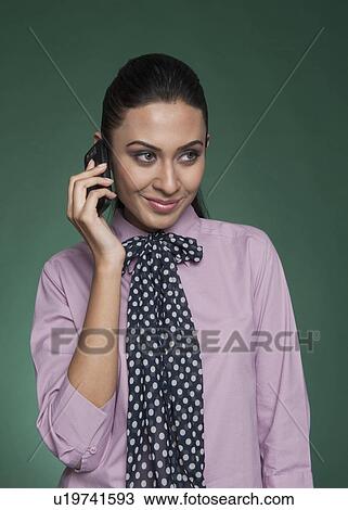 Stock Image - Businesswoman talking on a mobile phone and smiling. Fotosearch