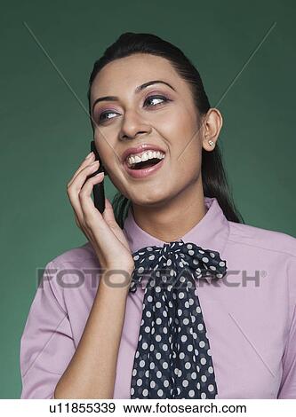 Businesswoman talking on a mobile phone and smiling View Large Photo Image Stock Photo - Businesswoman talking on a mobile phone and smiling. Fotosearch