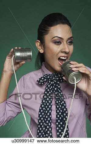Stock Photo - Businesswoman using a tin can phone. Fotosearch