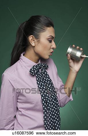 Stock Photograph - Businesswoman using a tin can phone. Fotosearch
