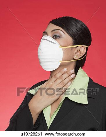 Stock Image - Businesswoman wearing a pollution mask. Fotosearch