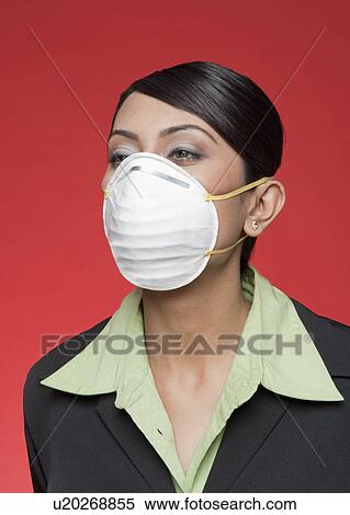 Stock Photography - Businesswoman wearing a pollution mask. Fotosearch