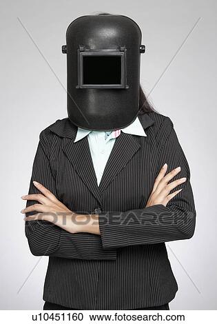 Stock Image - Businesswoman wearing a welding mask. Fotosearch