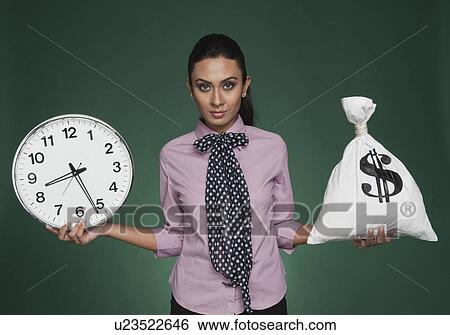 Businesswoman weighing time versus money View Large Photo Image Stock Photograph - Businesswoman weighing time versus money. Fotosearch