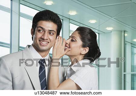 Stock Photo - Businesswoman whispering to a businessman. Fotosearch