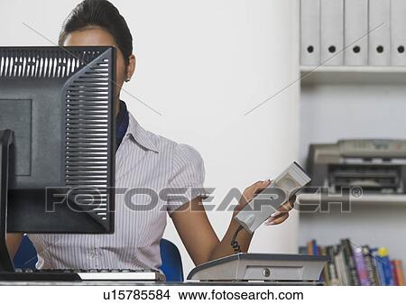 Businesswoman working on a desktop PC in an office View Large Photo Image Picture - Businesswoman working on a desktop PC in an office. Fotosearch