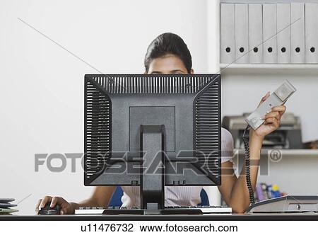 Businesswoman working on a desktop PC in an office View Large Photo Image Stock Image - Businesswoman working on a desktop PC in an office. Fotosearch