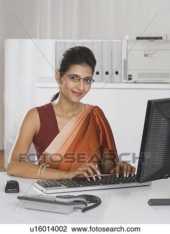Businesswoman working on a desktop PC in an office View Large Photo Image Stock Image - Businesswoman working on a desktop PC in an office. Fotosearch
