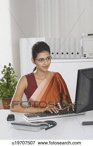 Businesswoman working on a desktop PC in an office View Large Photo Image Stock Photo - Businesswoman working on a desktop PC in an office. Fotosearch