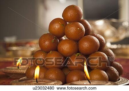 Candles burning around a tray of gulab jamuns View Large Photo Image Stock Image - Candles burning around a tray of gulab jamuns. Fotosearch