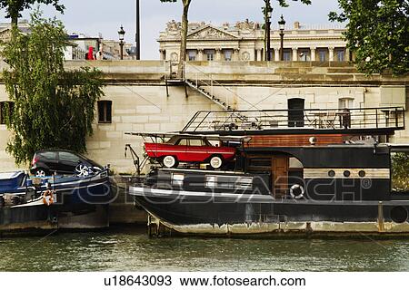 Stock Image - Cars being loaded on boats, Seine River, Paris, France. Fotosearch