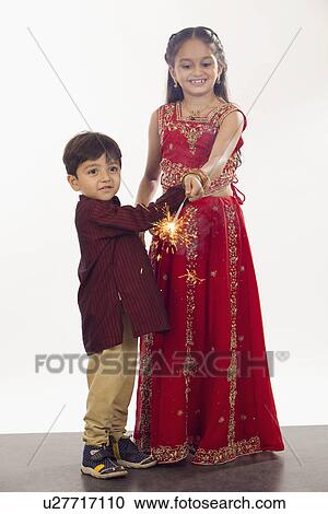 Stock Image - Children celebrating Diwali with sparklers. Fotosearch