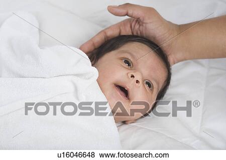 Close-up of a baby lying on the bed View Large Photo Image Stock Photo - Close-up of a baby lying on the bed. Fotosearch