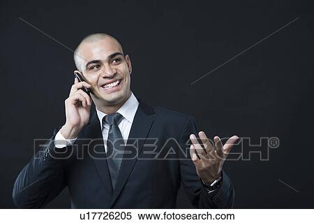 Close-up of a businessman talking on a mobile phone View Large Photo Image Stock Photography - Close-up of a businessman talking on a mobile phone. Fotosearch