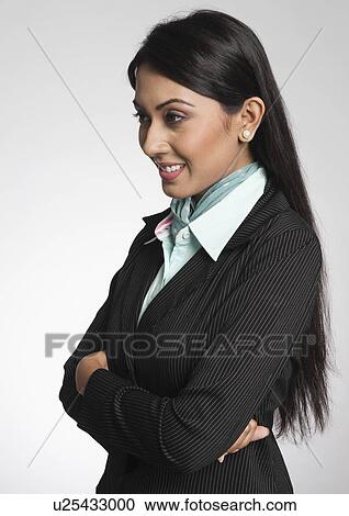 Stock Image - Close-up of a businesswoman with arms crossed and smiling. Fotosearch
