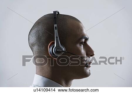 Picture - Close-up of a customer service representative wearing a headset. Fotosearch