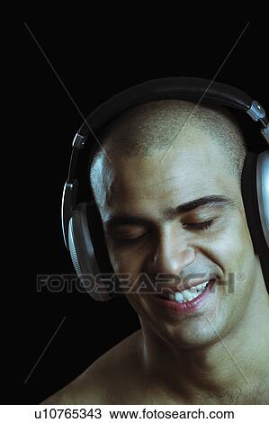 Close-up of a man listening to headphones View Large Photo Image Stock Image - Close-up of a man listening to headphones. Fotosearch