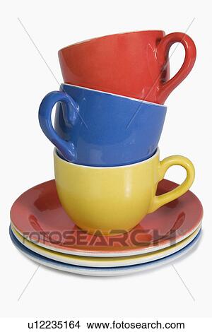 Picture - Close-up of a stack of colorful tea cups with saucers. Fotosearch