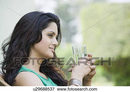 Close-up of a woman holding a glass of water View Large Photo Image Stock Photo - Close-up of a woman holding a glass of water. Fotosearch