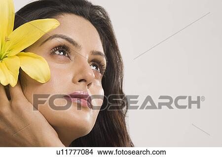 Close-up of a woman holding a Tiger Lily flower and day dreaming View Large Photo Image Picture - Close-up of a woman holding a Tiger Lily flower and day dreaming. Fotosearch