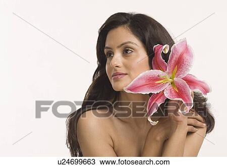 Stock Image - Close-up of a woman holding a Tiger Lily flower. Fotosearch