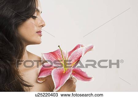 Stock Image - Close-up of a woman holding a Tiger Lily flower. Fotosearch
