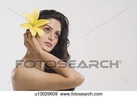 Stock Photo - Close-up of a woman holding a Tiger Lily flower. Fotosearch