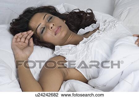 Stock Image - Close-up of a woman sleeping on the bed. Fotosearch