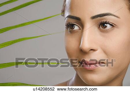 Close-up of a woman with palm leaves View Large Photo Image Stock Image - Close-up of a woman with palm leaves. Fotosearch