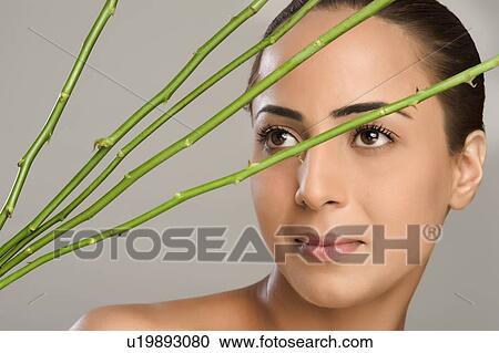 Close-up of a woman with rose stems in front of her face View Large Photo Image Stock Image - Close-up of a woman with rose stems in front of her face. Fotosearch